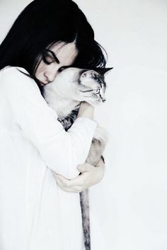 a woman holding a cat in her arms