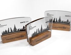 three award plaques with trees on them sitting next to each other in front of a white background