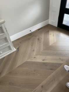 a person standing on top of a wooden floor next to a window with a ladder