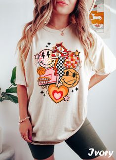 Get ready to rock that casual chic look with our Basketball Shirts For Women ❤️ Get retro with this Basketball Graphic Tee! Featuring smiley faces and a nostalgic vibe, this design is perfect for all the cool moms and game lovers out there. Show off your retro style and spread some positive vibes with this fun basketball t-shirt. ❤️ Size up, babe! Go 1-2 sizes bigger for that oversized stunner. Elevate your style, own the spotlight, and unleash your fashion power. It's time to rock the room with Cowgirl Halloween, Fleece Women, Comfort Colors Tshirt, Bride Shirt, Fabric Set, Mama Shirts, Shirts Women, Comfort Color, Extra Room