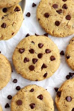 chocolate chip cookies on parchment paper with one cookie in the middle and more scattered around