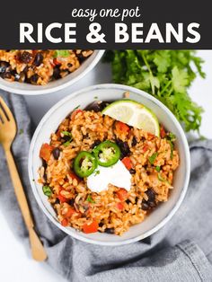 two bowls filled with rice and beans on top of a gray napkin next to a fork