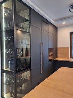 an empty kitchen with glasses on display in the cabinet doors and counter top area,