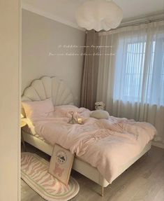 there is a large bed with pink comforter and pillows on the floor in this bedroom