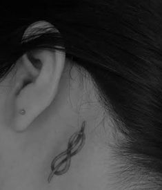 a woman's ear with a small tattoo on it