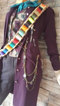 a mannequin wearing a purple suit and colorful necklaces on it's neck