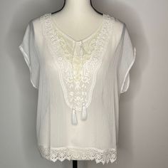 Ariat Sheer White Blouse Short Sleeve Light Weight Polyester Heavy Embroidered Detail At Front Bodice Split Neck Line With Cording Details Lace Trim Detail New - Never Worn Excellent Condition See Photos For Measurements And Details Measurements By Hand, May Vary Slightly Embroidered Short Sleeve Lace Blouse, Short Sleeve Embroidered Lace Blouse, Embroidered Lace Blouse With Short Sleeves, Short Sleeve Blouse With Crochet Trim For Vacation, Elegant Floral Embroidery Top For Vacation, Elegant Floral Embroidered Top For Vacation, Short Sleeve Lace Blouse For Beach, Lace Short Sleeve Beach Blouse, Lace Short Sleeve Blouse For Beach