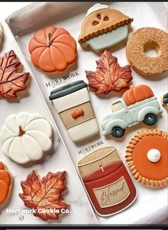 an assortment of decorated cookies in the shape of fall leaves, pumpkins and cars