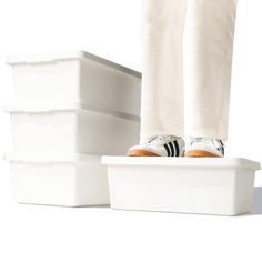 a person standing on top of three white containers