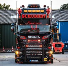 a large semi truck parked in front of a building