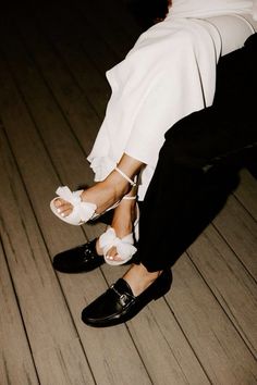 a bride and groom are sitting on the floor with their feet up in white shoes