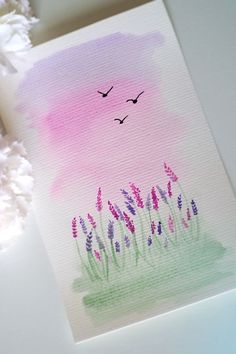 a watercolor painting with birds flying over the grass and flowers on the table next to it