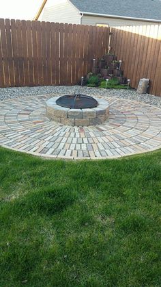 an outdoor fire pit surrounded by grass