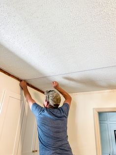 a man is working on the ceiling in his home