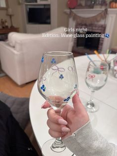 a person holding up a wine glass in front of a table with glasses on it