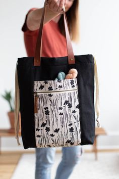 a woman holding a black and white bag