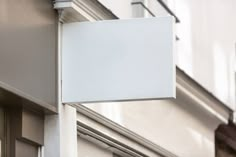 a white sign hanging from the side of a building