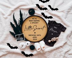 a baby announcement surrounded by bats and other items on a white sheet with black lettering