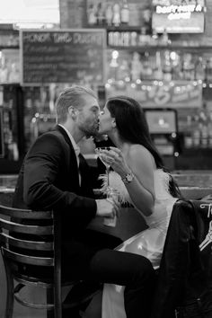 a man and woman sitting at a table kissing