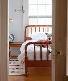 a dog laying on top of a bed in a bedroom