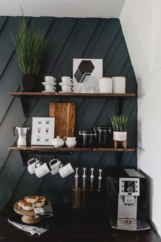 a coffee maker and some cups on a shelf