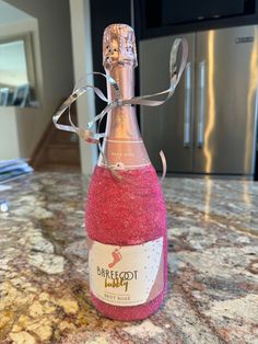 a bottle of sparkling pink wine sitting on top of a counter