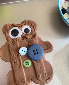 a cookie shaped like a bear with buttons in it's mouth and eyes on top of a counter