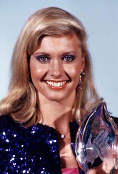 a woman holding an award in front of her face and smiling at the camera stock photo