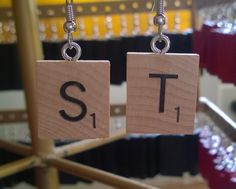 two wooden blocks with the letters s1 and t1 hanging from hooks in a store