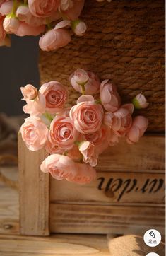 some pink flowers are hanging from a basket