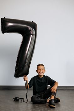 a young boy sitting on the floor with an inflatable balloon