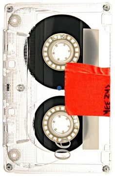 an old fashioned cassette with a red cloth on it's side and two black discs in the middle