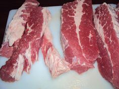 two steaks are cut up on a cutting board with a knife next to them