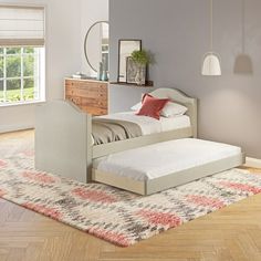 a bed sitting on top of a wooden floor next to a dresser and window in a bedroom