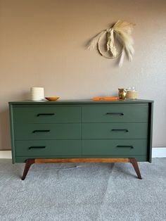 a green dresser sitting in front of a wall