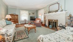 a living room filled with furniture and a fire place in the middle of a room