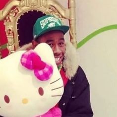 a man holding a hello kitty stuffed animal