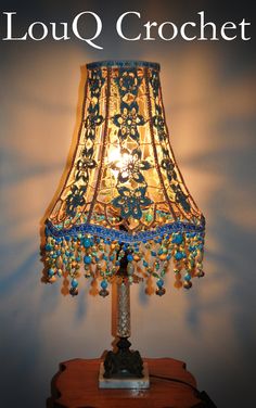 a lamp that is sitting on top of a wooden table with the words louis crochet above it