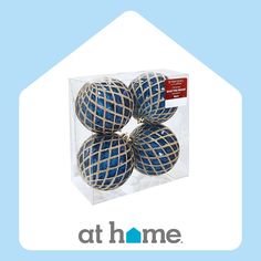 four blue balls in a clear box with the words at home on it's side