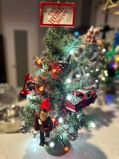 a small christmas tree with lights on it and a firetruck ornament