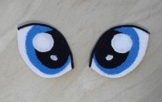 two blue eyes with black and white stripes on the bottom one has an eyeball in it's center