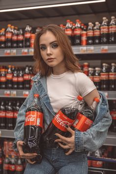 a woman holding two soda cans in her hands