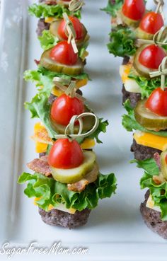 mini burgers with tomatoes, lettuce and pickles on them are ready to be served