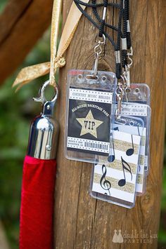 two tags attached to a wooden pole with a red umbrella in the foreground and music notes on it