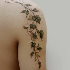 the back of a woman's shoulder with vines and leaves on it