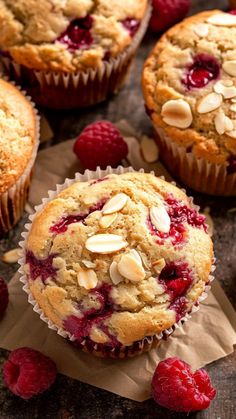 fresh raspberry muffins with almonds on top and some raspberries