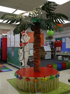 a palm tree in the middle of a classroom with decorations on the walls and floor