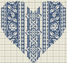 a cross stitch pattern with blue and white designs on the front, in an intricate heart shape