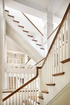 a white staircase with wooden handrails in a home