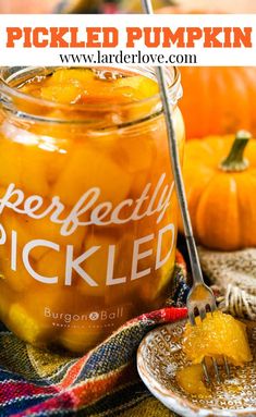 a jar filled with pickled pumpkins sitting on top of a table next to a plate